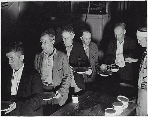 Feeding the Unemployed.  Men at a soup kitchen in Washington, D.C., 1936. U.S. Federal Government photograph. Public domain.