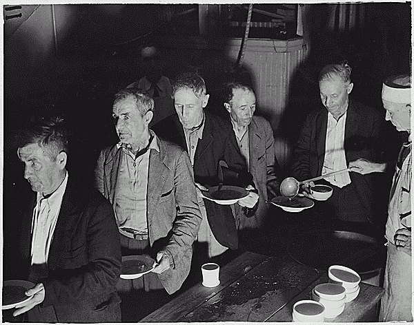 Feeding the Unemployed.  Men at a soup kitchen in Washington, D.C., 1936. U.S. Federal Government photograph. Public domain.
